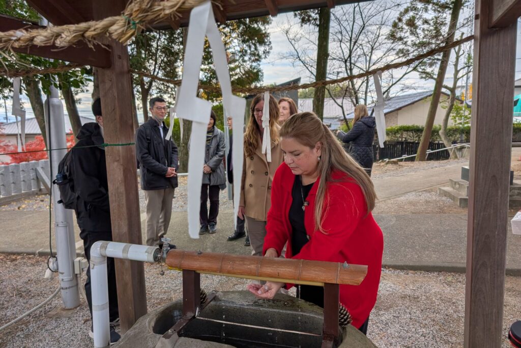 Local older residents explained how to pray at a Japanese shrine to participants